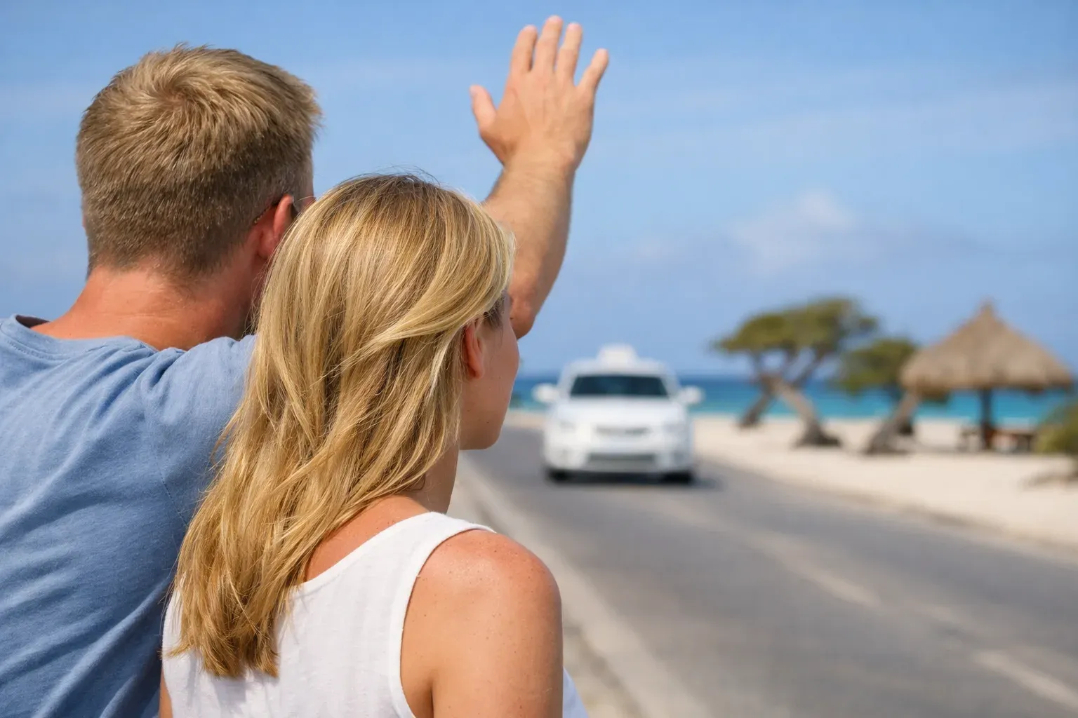Couple trying to hail a taxi along Eagle Beach in Aruba