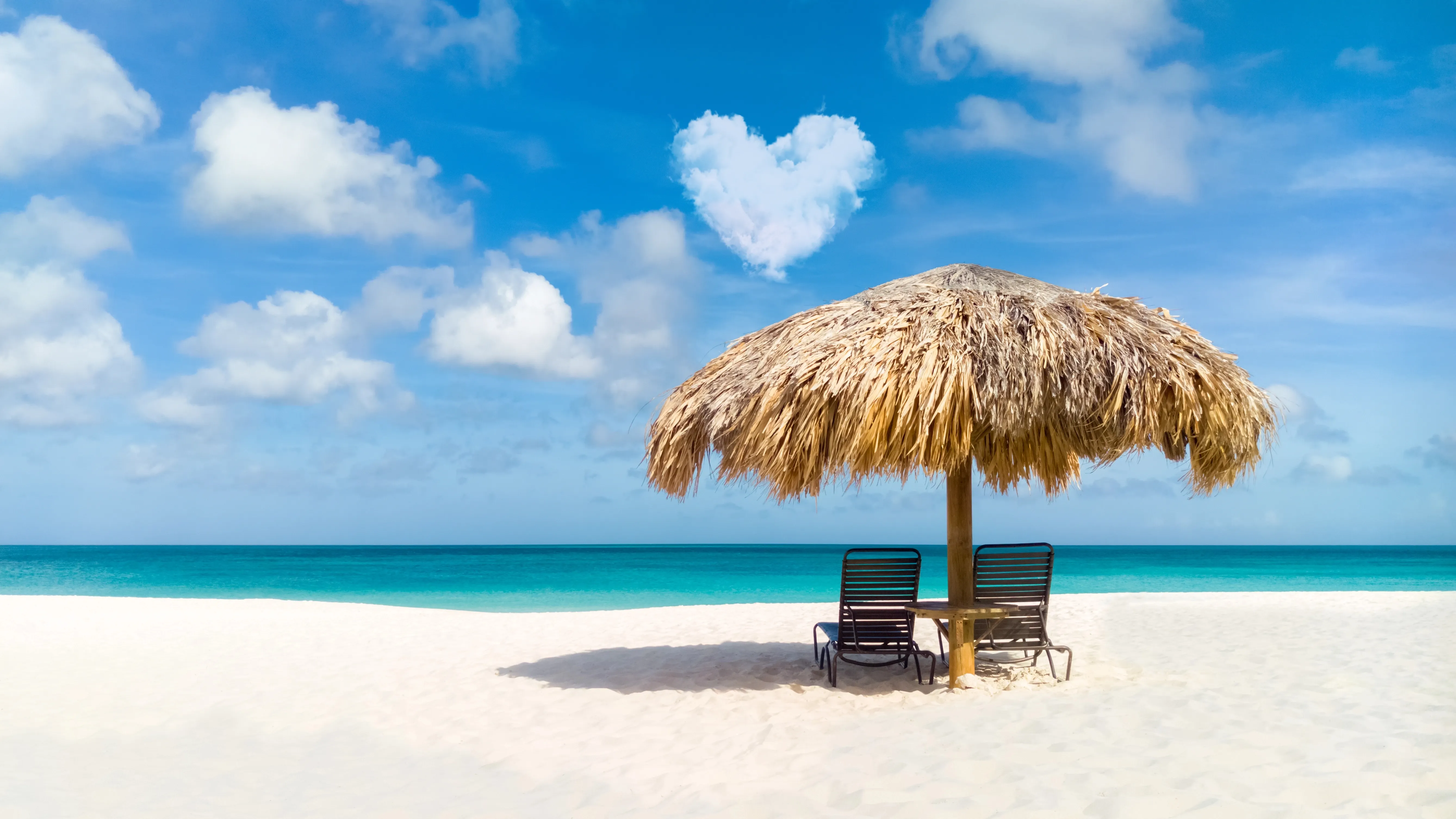 Aruba beach with turquoise water, white sand and chiki hut.